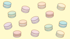 マカロンが散りばめられた黄色の背景画像